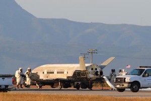 I tecnici al lavoro sull'X-37B appena atterrato sulla pista della base dell'USAF di Vandenberg, il 16 Giugno 2012, dopo aver concluso la sua seconda missione, durata 469 giorni.  Da notare le misure precauzionali per evitare di venire a contatto con i residui dell'Idrazina (C) Boeing