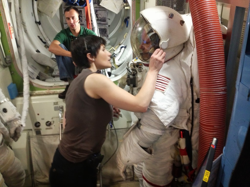 Samantha Cristoforetti aiuta un collega astronauta a indossare la tuta EMU per EVA. Fonte: Josh Matthew
