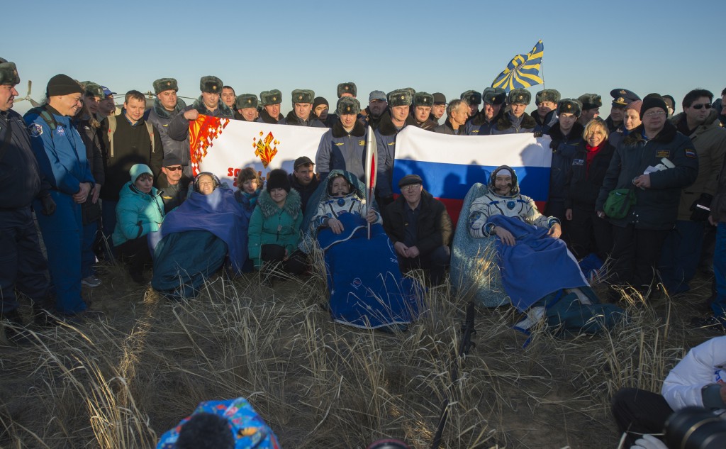 NASA Flight Engineer Karen Nyberg, left, Expedition 37 Commander Fyodor Yurchikhin of Roscosmos, center, and European Space Agency Flight Engineer Luca Parmitano sit in chairs outside the Soyuz capsule just minutes after they landed in Kazakhstan. Image Credit: NASA/Carla Cioffi