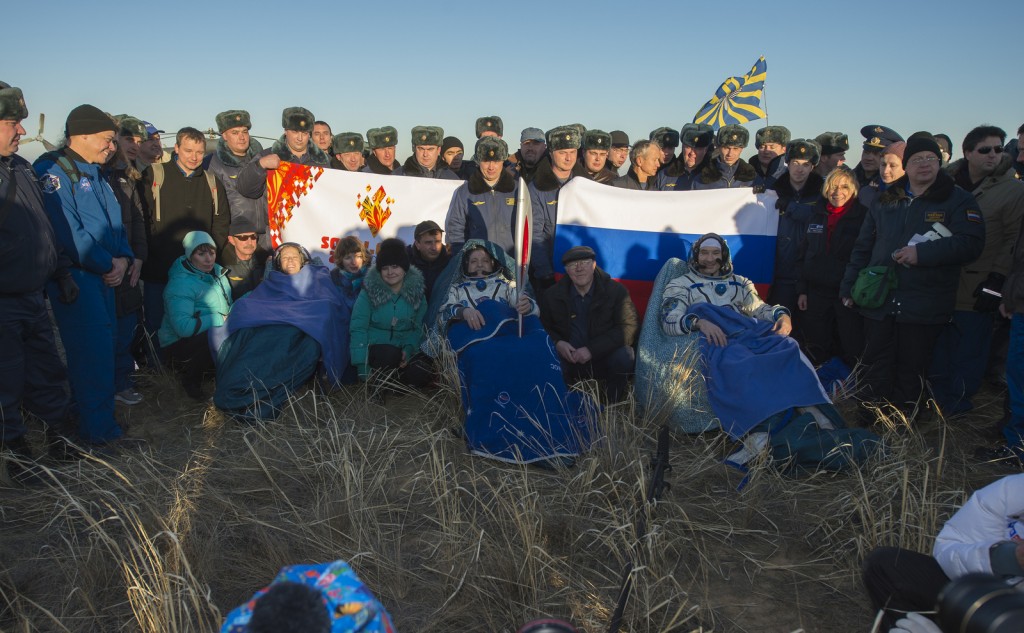 NASA Flight Engineer Karen Nyberg, left, Expedition 37 Commander Fyodor Yurchikhin of Roscosmos, center, and European Space Agency Flight Engineer Luca Parmitano sit in chairs outside the Soyuz capsule just minutes after they landed in Kazakhstan. Image Credit: NASA/Carla Cioffi