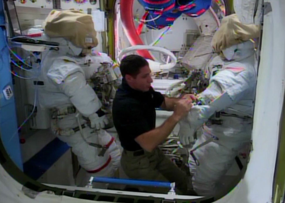 L'astronauta della NASA Micke Hopkins lavora per prepare le tute spaziale per la EVA odierna. Credit: NASATV.