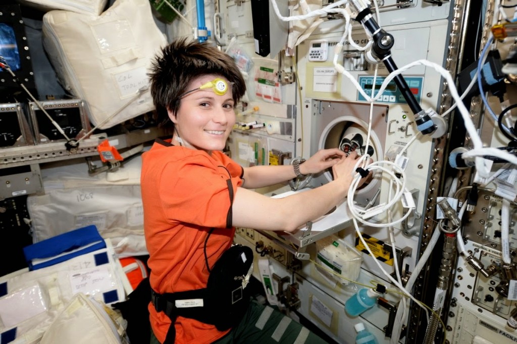 Samantha Cristoforetti Inserisce dei campioni di sangue in una centrifuga. Credit: ESA/NASA