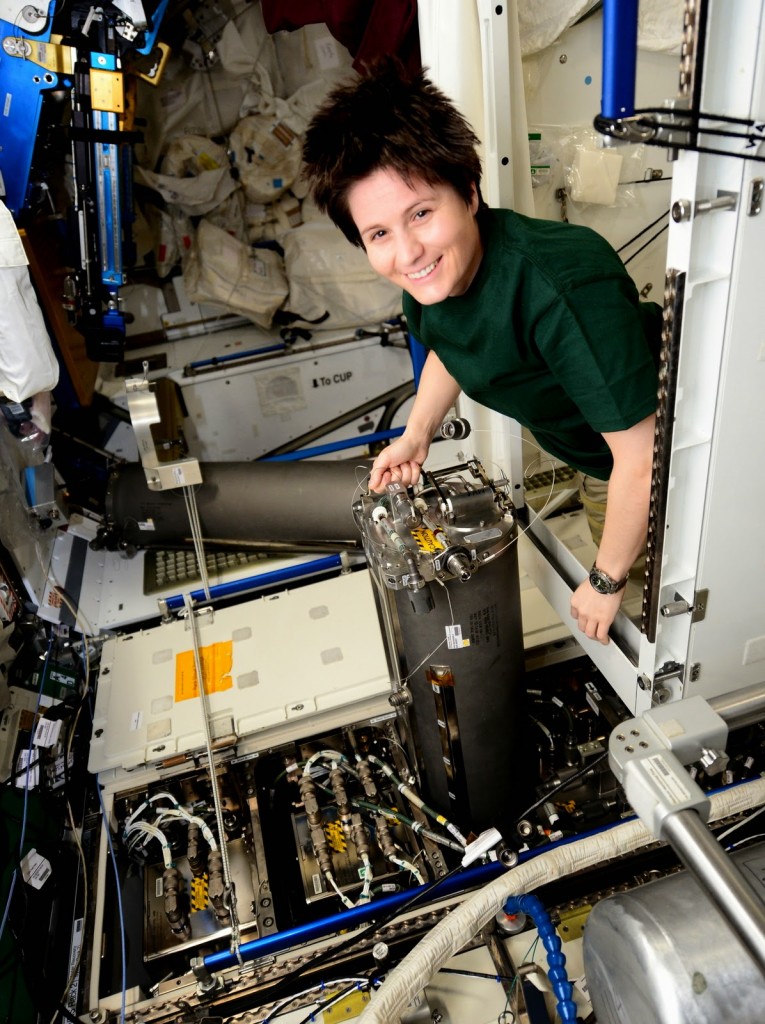 Samantha Cristoforetti sostituisce un serbatoio di scarti del riciclaggio dell'urina. Credit: ESA/NASA