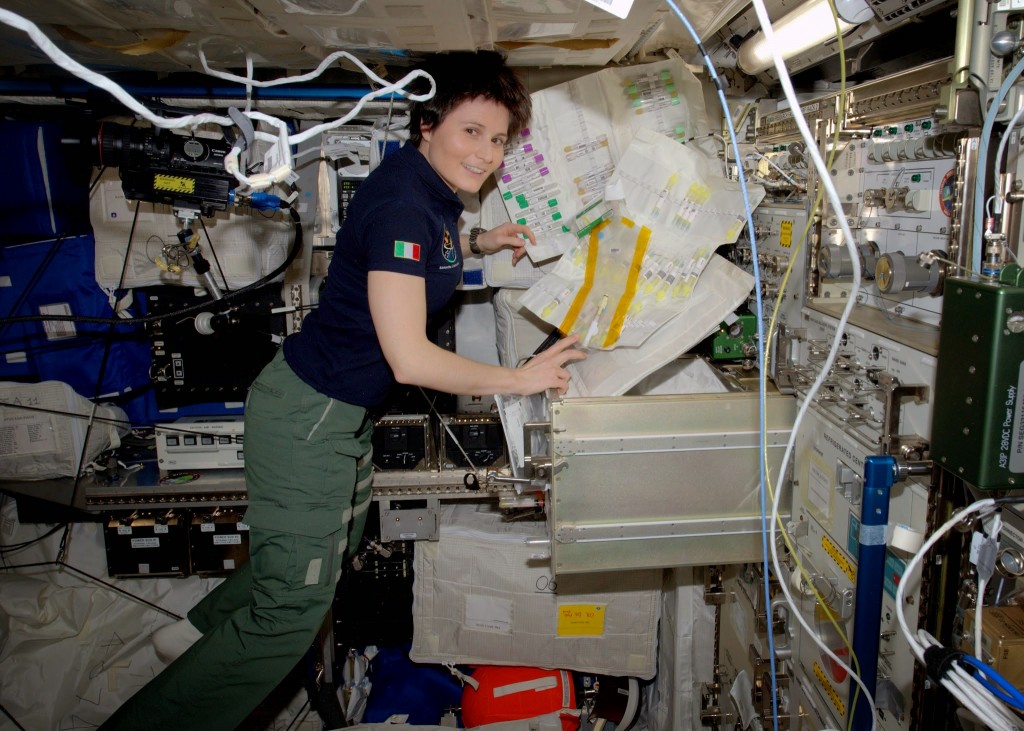 Samantha Cristoforetti aon alcune attrezzature di laboratorio per la ricerca sull'uomo. Credit: ESA/NASA