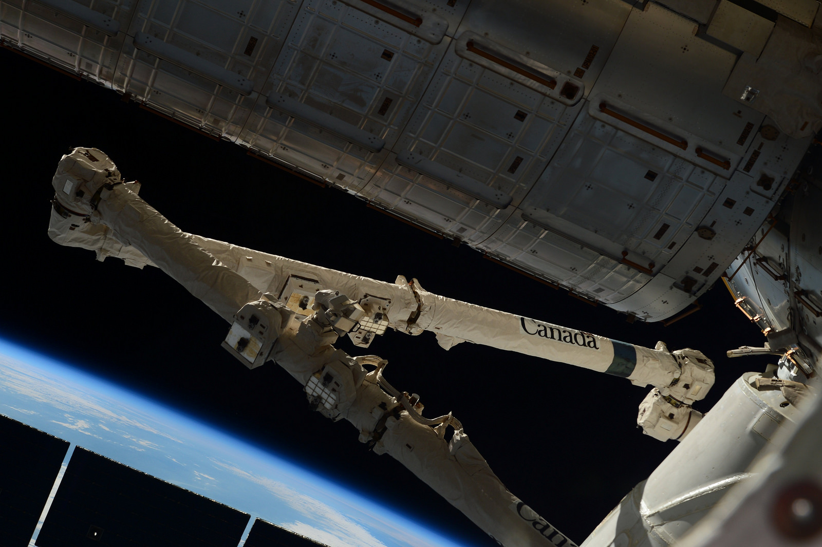 Il braccio robotico Canadarm 2 della ISS agganciato al Cargo Dragon CRS-6. Credit: ESA/NASA