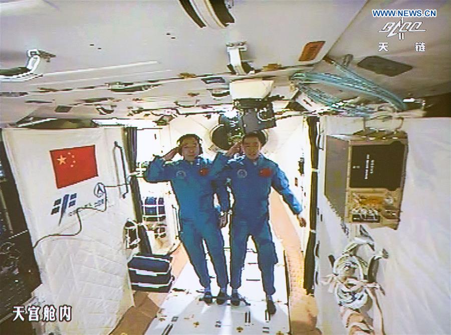 Jing Haipeng e Chen Dong fanno il saluto militare poco dopo il loro ingresso in Tiangong-2 (Credit: Xinhua/Ju Zhenhua)